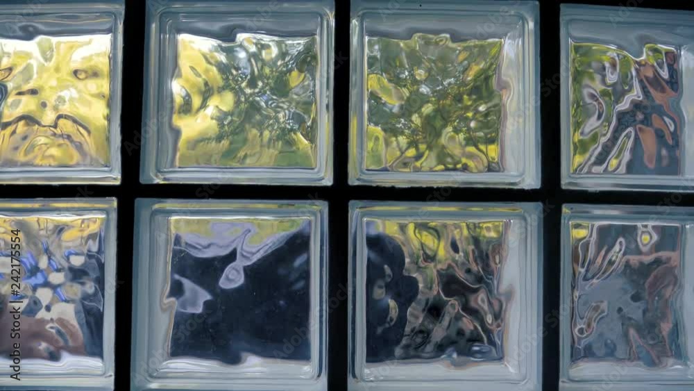 Close up view of a glass block window. Scenery outside is distorted and ...