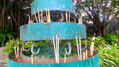 Handheld pan shot, of a holder, full with smoking insence, in Chiang rai, Thailand photo