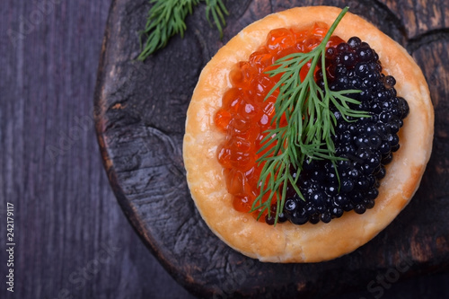 Red and black caviar in a tartlet garnished with dill