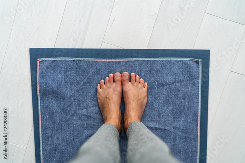 Yoga mat hot bikram yoga class - girl taking pov selfie of feet standing on towel in studio. Top view on floor. photo