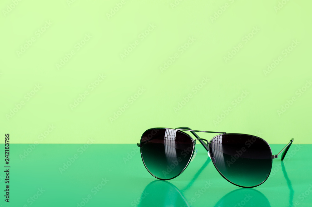 Sunglasses fashion summer accessory on green background Sunglasses fashion summer accessory on green background