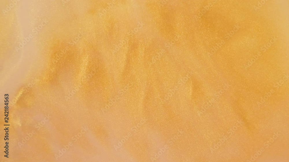 Colorful golden sand organically moves in colorful liquid