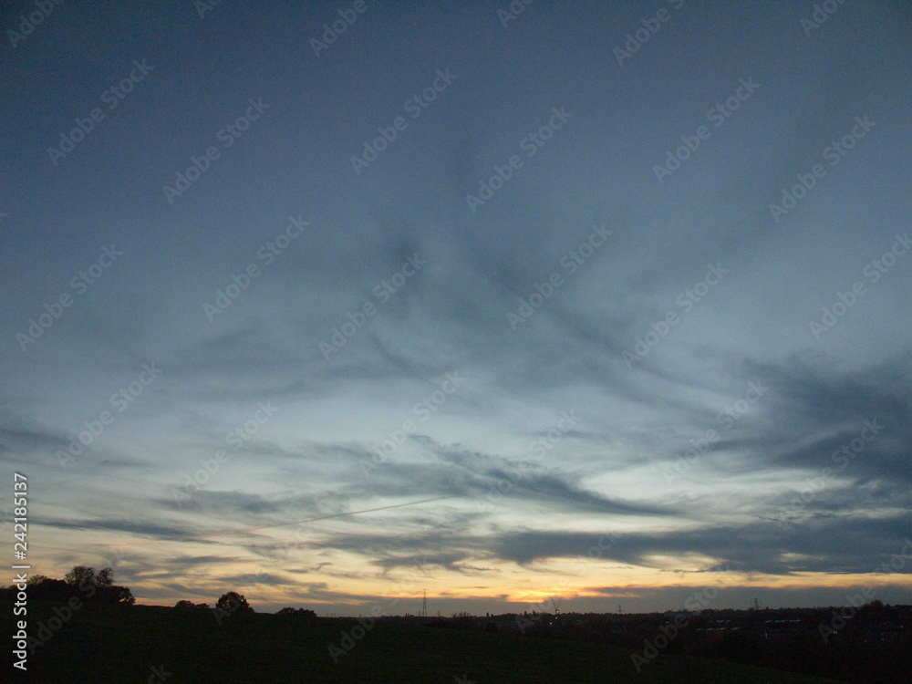cloudy nighttime sunset sky blue sky treeline empty space cloudy nighttime sunset sky blue sky treeline empty space
