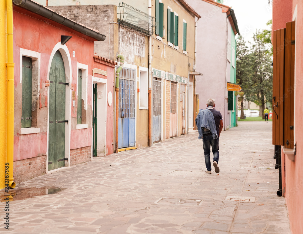 man walking on the street in Burano, Venice, Italy man walking on the street in Burano, Venice, Italy
