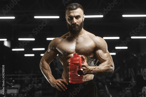 Handsome strong athletic muscles men drink water and sport nutrition workout bodybuilding concept background