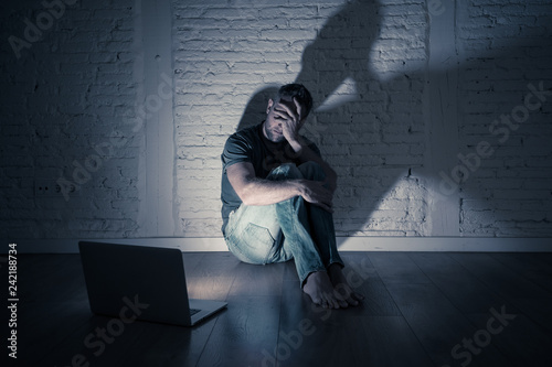Εκτύπωση καμβά Men suffering Internet cyber bullying sitting alone with computer feeling hopele