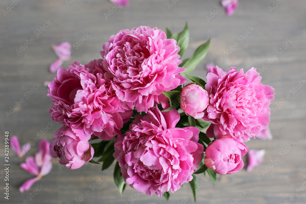 Fototapeta premium Flowers composition. Pink peony flowers on wooden background. Mothers day. Flat lay, top view.