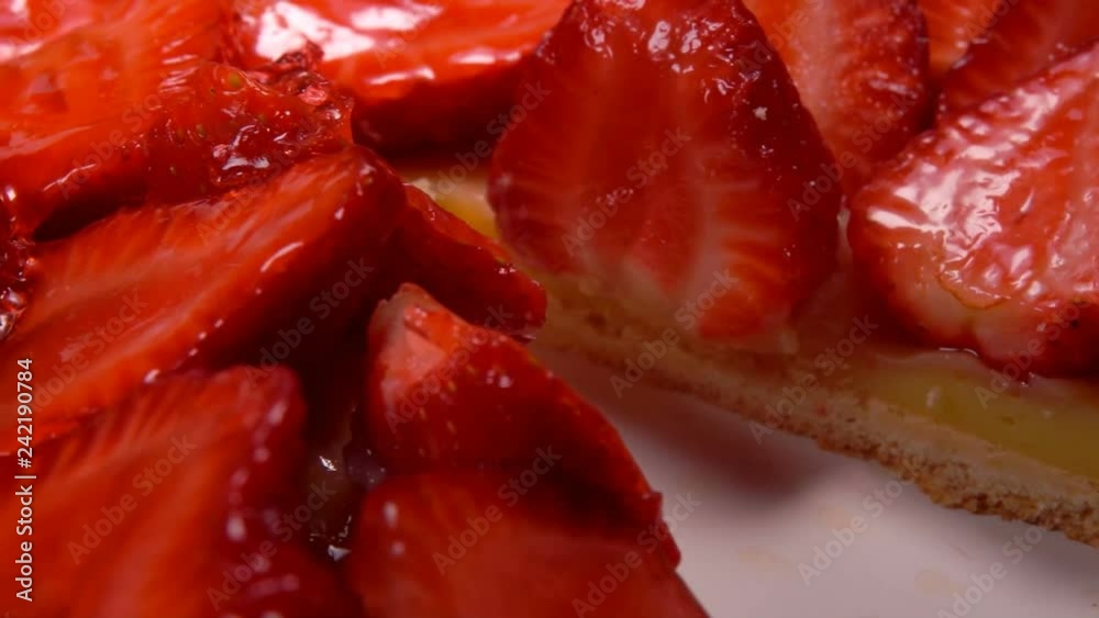 Knife cuts off a piece of Fresh Strawberry Pie covered with jelly. Close-up of a piece of strawberry pie taken out with a spatula Knife cuts off a piece of Fresh Strawberry Pie covered with jelly. Close-up of a piece of strawberry pie taken out with a spatula