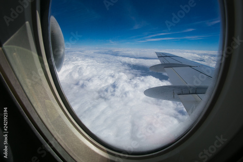 Fotografie View from the window of the plane onto the wing and engines of a fokker 100 model with a blue sky and white clouds