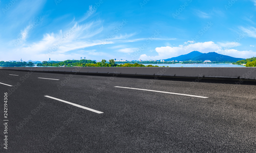 Fototapeta premium Empty asphalt road square and natural landscape under the blue sky