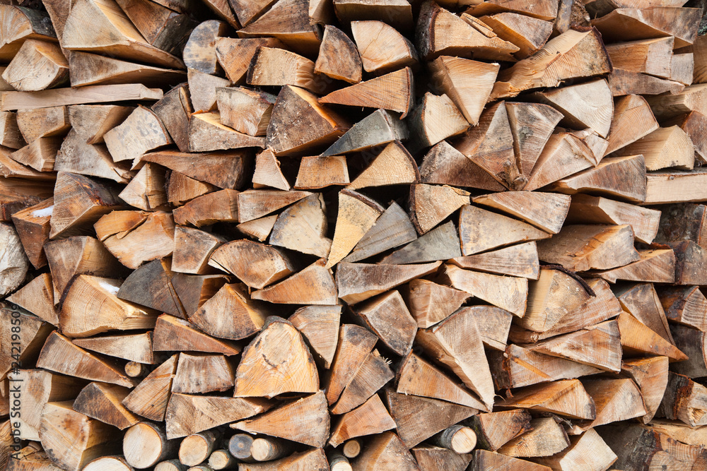 Pile of firewood, logs close-up. Natural wooden background. Reserve for winter and alternative energy source Pile of firewood, logs close-up. Natural wooden background. Reserve for winter and alternative energy source