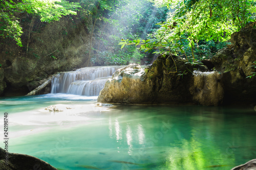 Fototapeta Naklejka Na Ścianę i Meble -  Erawan waterfall, National Park, Kanchanaburi, Thailand. Empty waterfall with sun rays shining through green foliage.