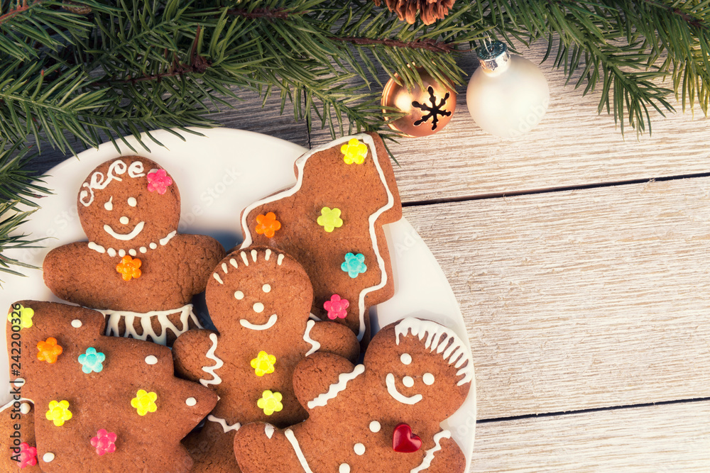 Gingerbread cookies and Christmas tree branch on a wooden table. Directly above. Christmas holiday concept. Gingerbread cookies and Christmas tree branch on a wooden table. Directly above. Christmas holiday concept.