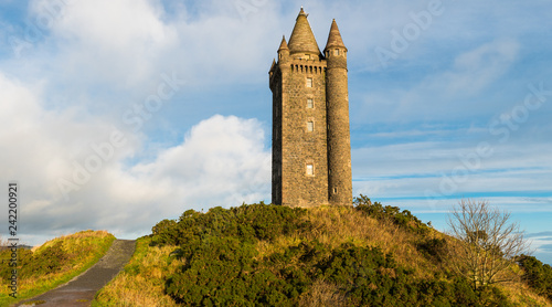 Canvas Print Panoramic view of a path leading to an old hilltop castle tower under a blue sky