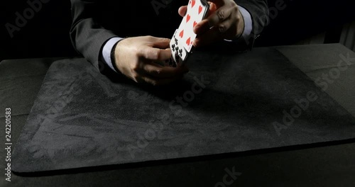 Man performs Faro Shuffle, charlier cut,  then cuts deck of cards into 3 piles.