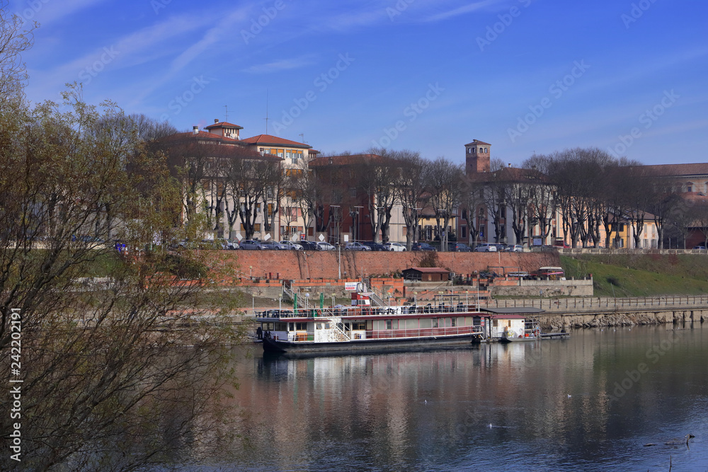 fiume po con barca a pavia in italia in europa, po river with boat and historic building in italy, europe