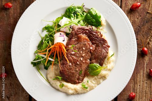 Rib-eye steak with sweet potato-herb purée and leaf lettuce