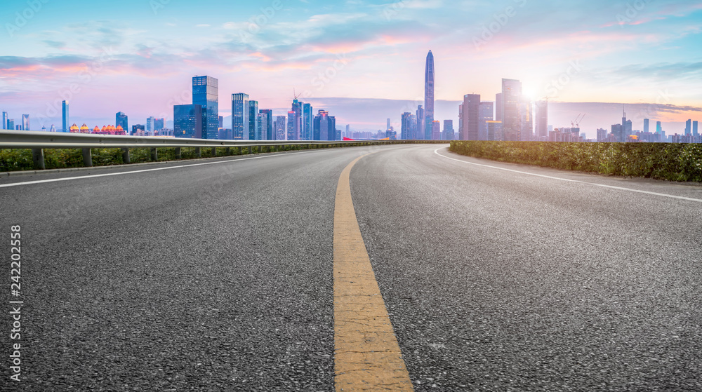 Empty asphalt road along modern commercial buildings in China,s cities Empty asphalt road along modern commercial buildings in China,s cities