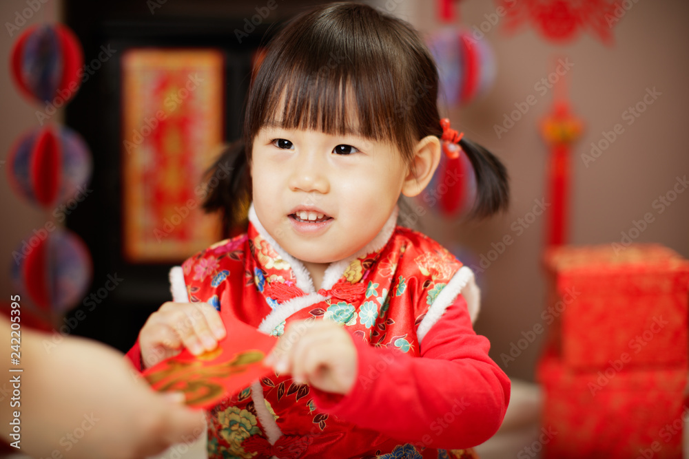 Chinese baby girl traditional dressing up with a FU means lucky red envelope Chinese baby girl traditional dressing up with a FU means lucky red envelope