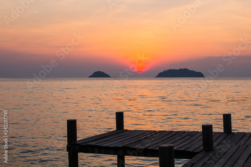 Wooden pontoons on sea coast during amazing sunset.