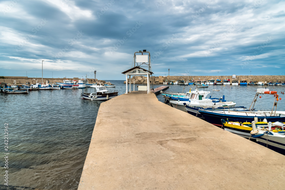 Fototapeta premium Pier with boats of Isola delle Femmine or the Island of Women located on the shore of Mediterranean sea in province of Palermo, Sicily, Italy