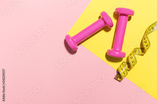 Dumbbells flat lay on pink and yellow background © nerudol