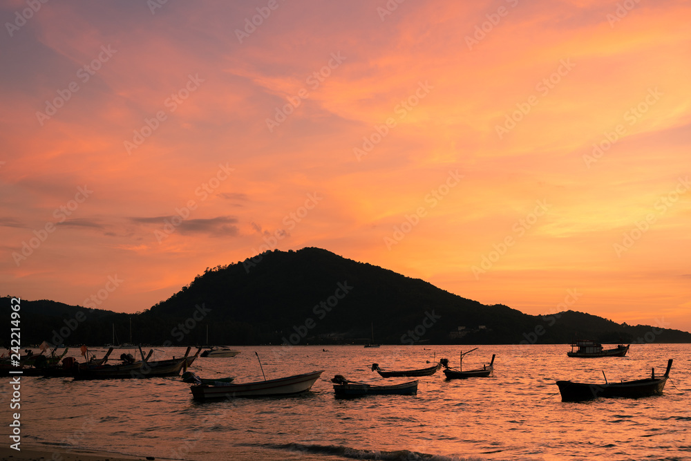 Background sky sunset,Silhouette Thai boat love travel to the beach adventure,Bright in Phuket Thailand. Background sky sunset,Silhouette Thai boat love travel to the beach adventure,Bright in Phuket Thailand.