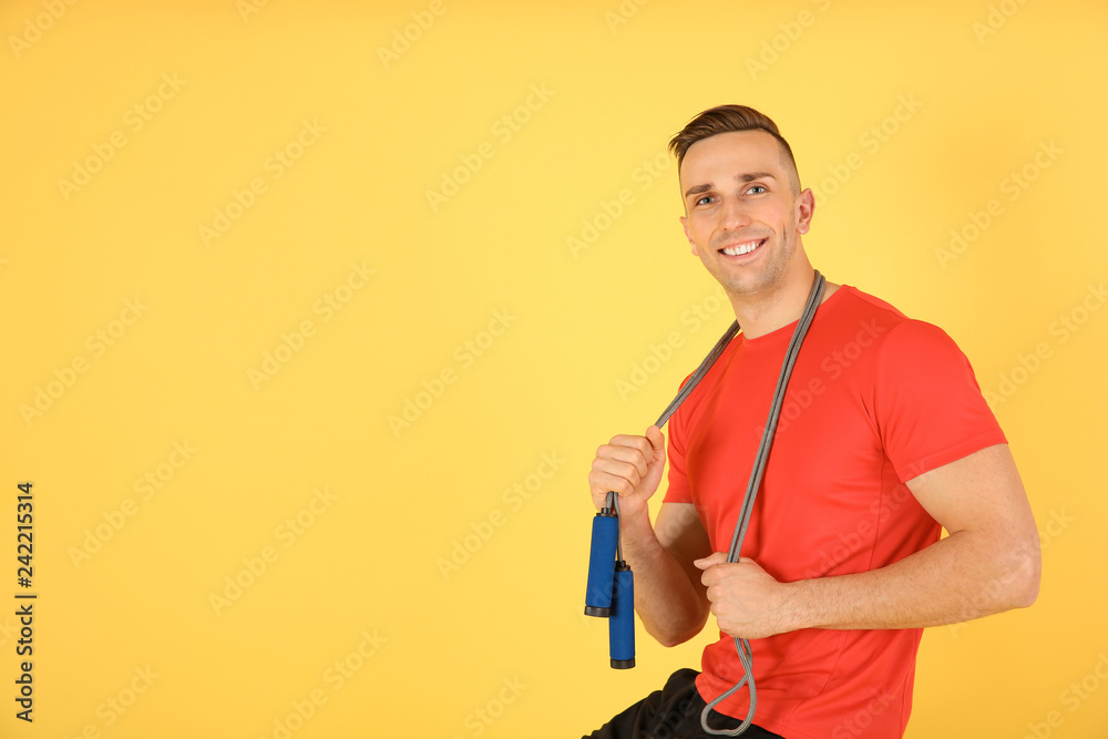 Portrait of young sportive man with jump rope on color background. Space for text Portrait of young sportive man with jump rope on color background. Space for text
