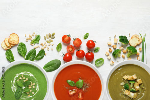 Flat lay composition with various soups and ingredients on white background. Healthy food