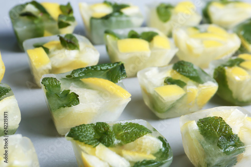 Ice cubes with mint and lemon on grey background
