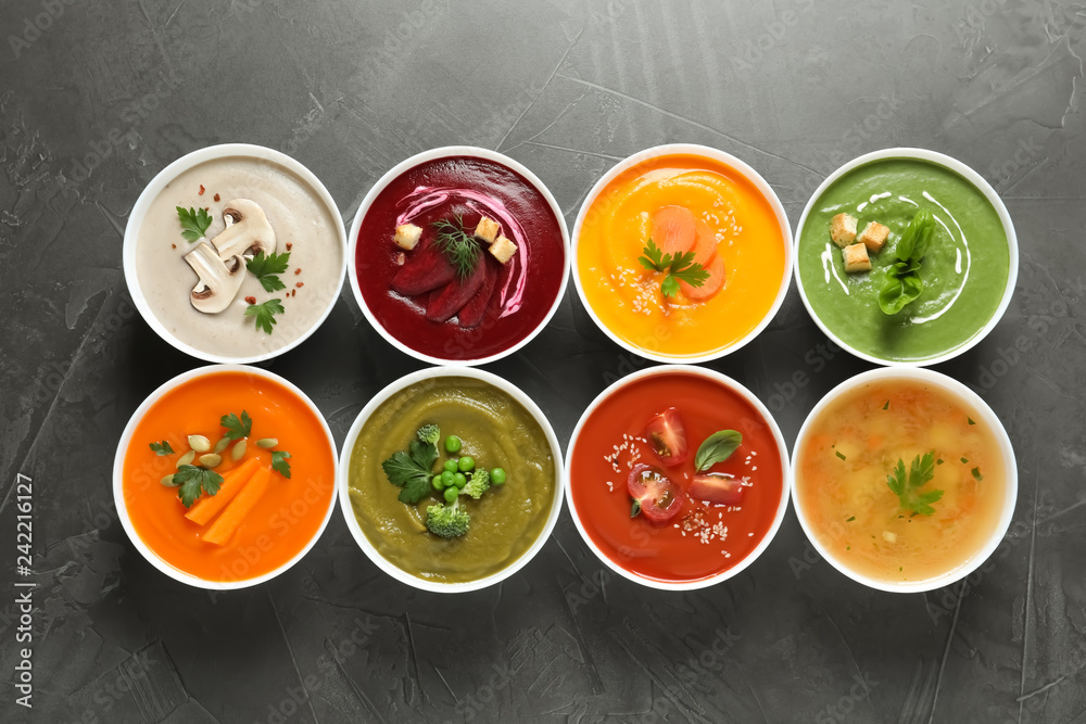 Various cream soups in bowls on grey background, top view Various cream soups in bowls on grey background, top view