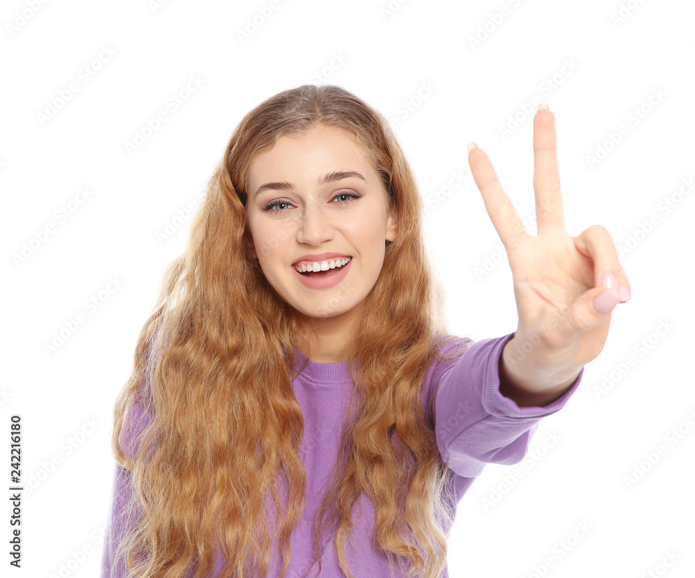 Happy young woman showing victory gesture on white background Happy young woman showing victory gesture on white background
