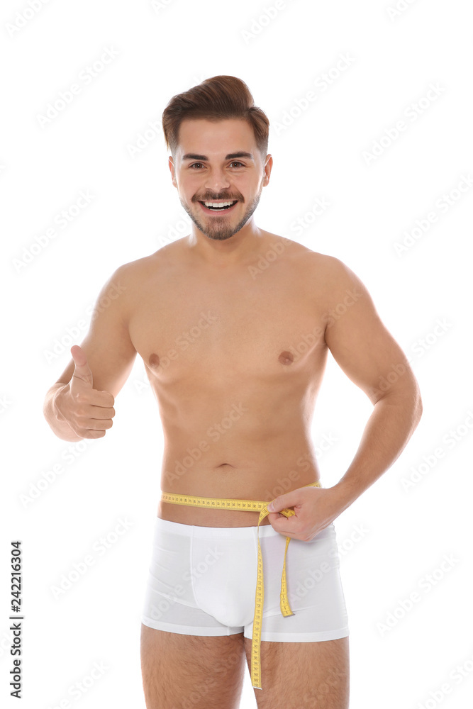 Fit man measuring his waist on white background. Weight loss Fit man measuring his waist on white background. Weight loss