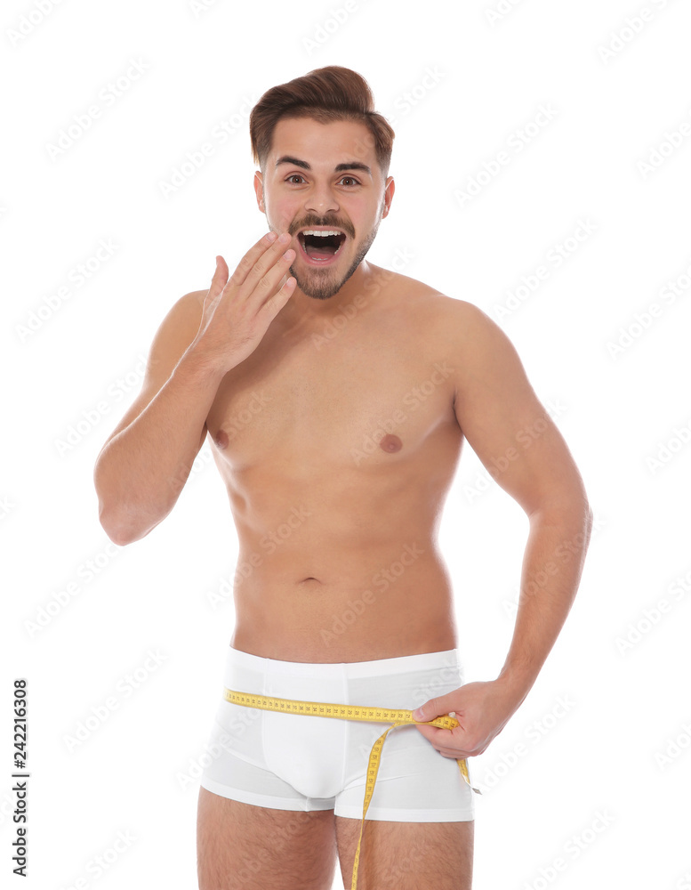 Fit man measuring his hips on white background. Weight loss Fit man measuring his hips on white background. Weight loss