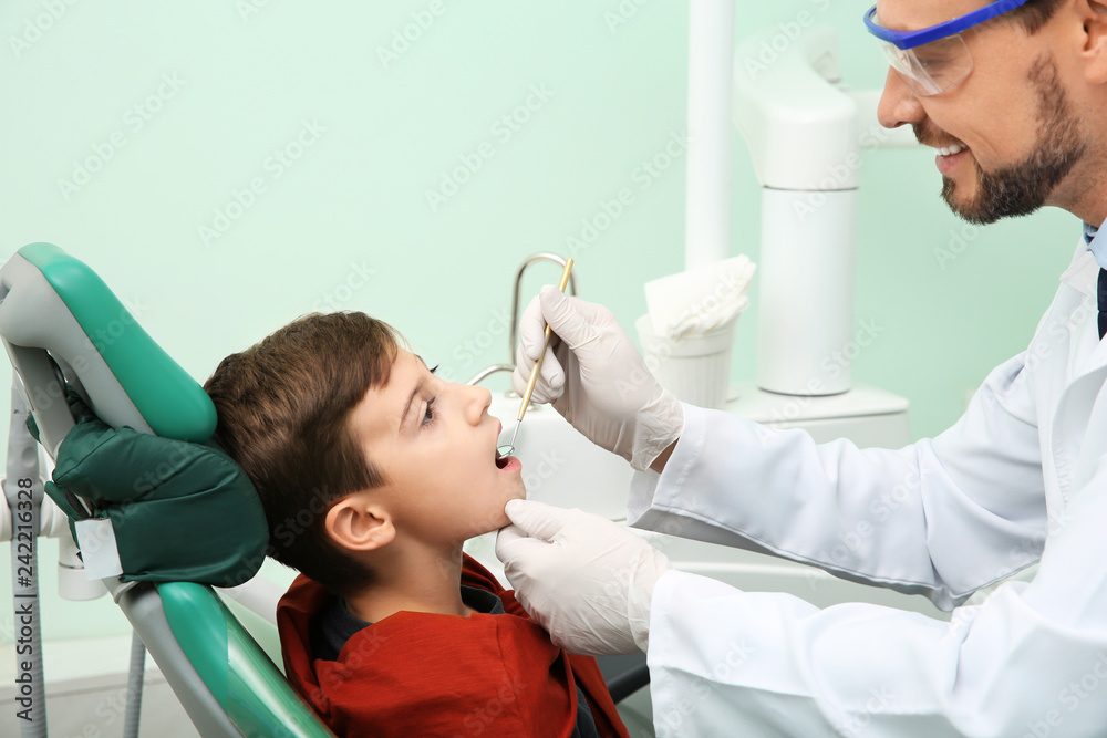 Professional dentist working with little patient in modern clinic Professional dentist working with little patient in modern clinic