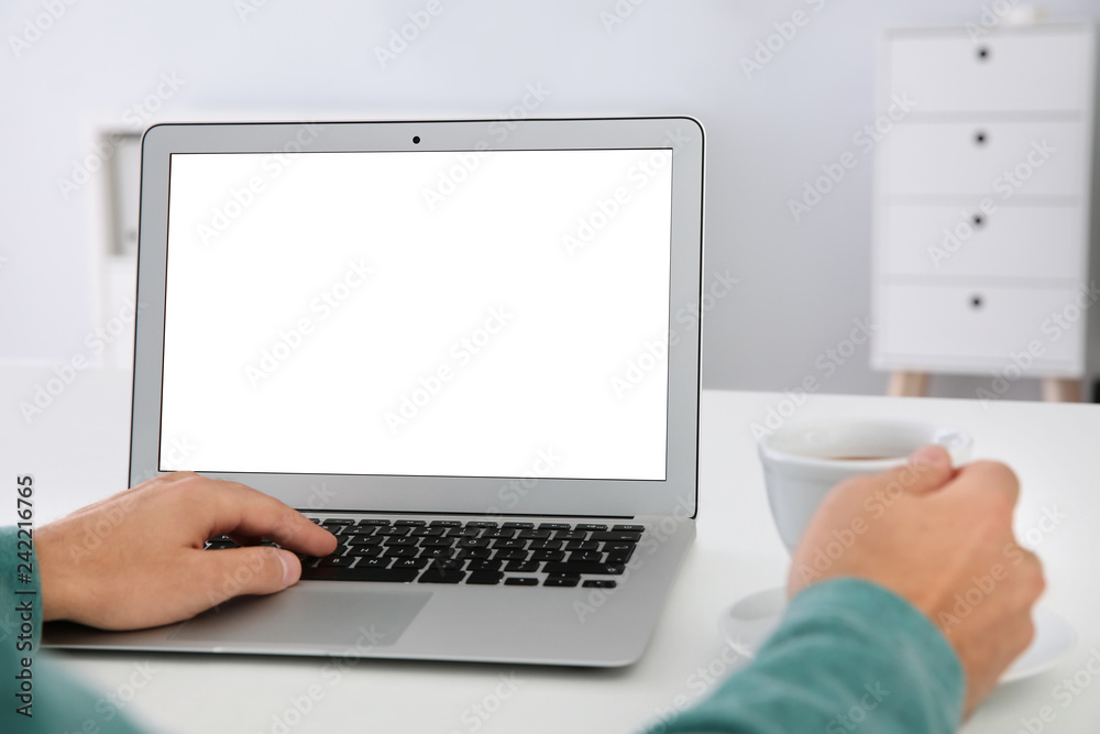Young man working with modern laptop at table, closeup. Mockup for design Young man working with modern laptop at table, closeup. Mockup for design