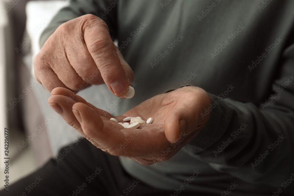 Fototapeta premium Senior man taking pills, closeup of hands