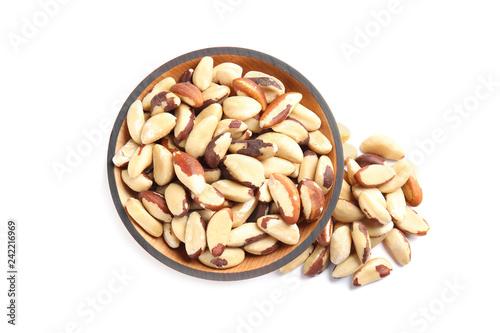 Wooden bowl with Brazil nuts on white background, top view