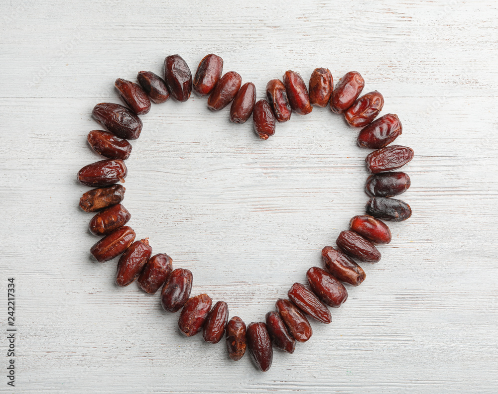 Frame made of sweet dried date fruits on wooden background, top view with space for text Frame made of sweet dried date fruits on wooden background, top view with space for text