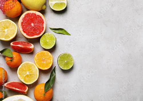 Different citrus fruits on grey background, top view. Space for text © New Africa