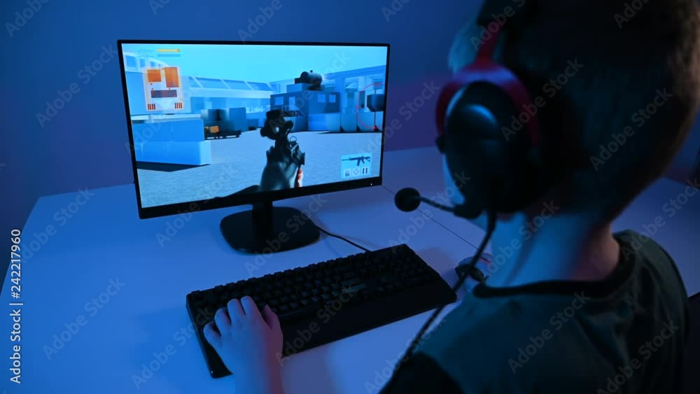 Boy plays violent online video game on pc and shoots with a gun