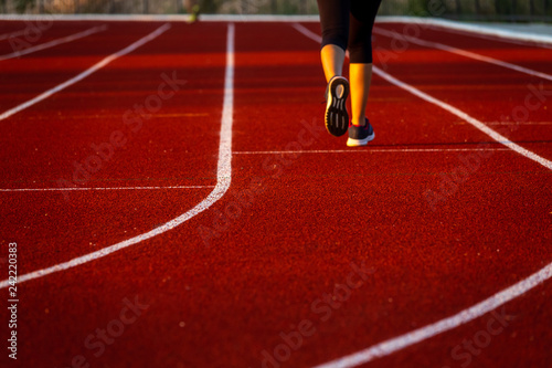 Red running track with runner s feet. Sport stadium for run.