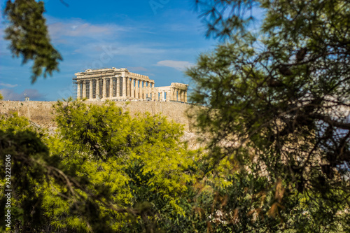 Acropolis world famous heritage touristic site object antique building from ancient Greece times landmark photography in park outdoor nature plant branches frame 