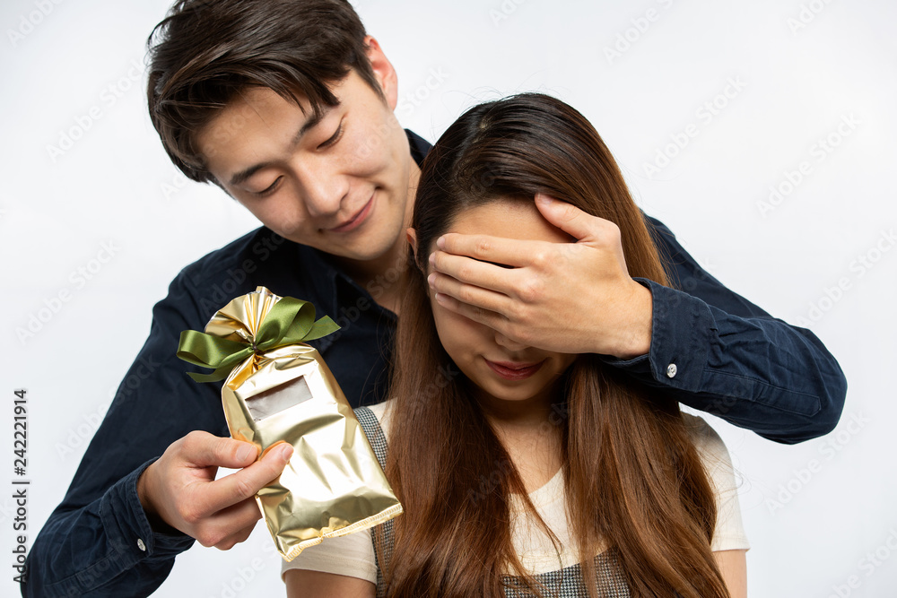 女性に目隠しをしてサプライズプレゼントを渡す男性 Stock Photo Adobe Stock 女性に目隠しをしてサプライズプレゼントを渡す男性 Stock Photo Adobe Stock