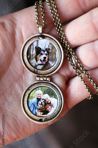 Konstfotografi Woman's Hand Holding Antique Locket with Photos of Children and Pet Dog Inside