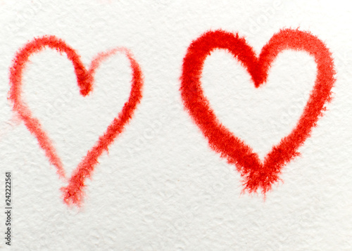 two red hearts drawn with watercolor on watercolor paper. symbol of love and romance.
