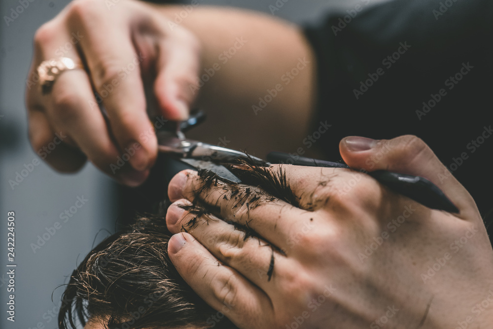 Men's hairstyling and haircutting in a barber shop or hair salon. Men's hairstyling and haircutting in a barber shop or hair salon.