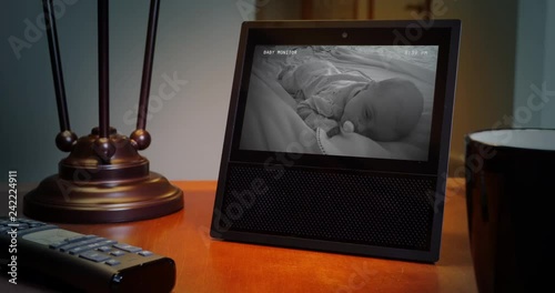 A slow push in dolly shot of a baby monitor on a home's living room end table.  	 photo