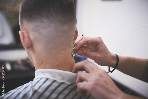 Professional barber styling hair of his client