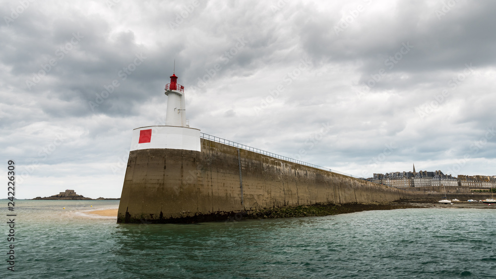 Pier, lighthouse and city of Saint Malo on a cloudy day in summer